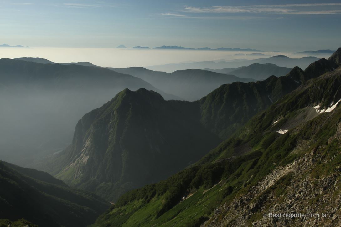 Islands of mountains in a sea of clouds, with Mount Fuji in the background, while hiking the Japanese Alps.