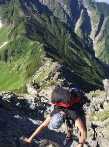 Hiker climbing up along the Daikiretto ridgeline hike in the Japanese Alps.