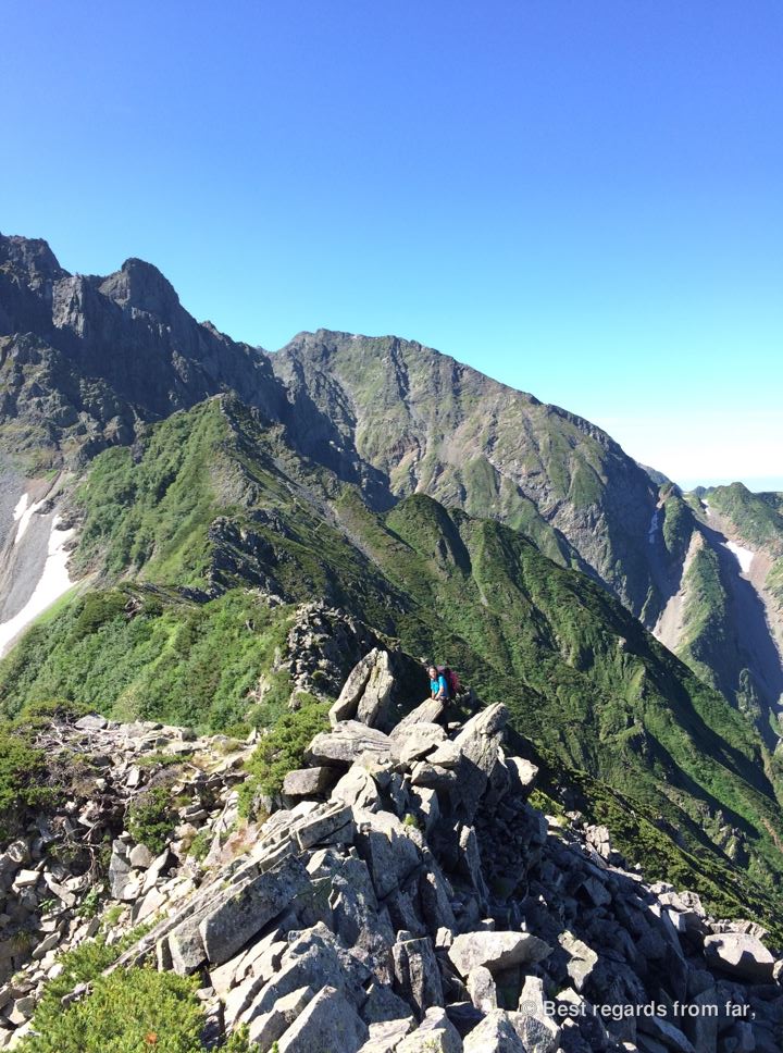 Tiny-looking hiker on the Daikiretto ridge line in the Japanese Alps giving a sense of scale to the high surrounding mountains.