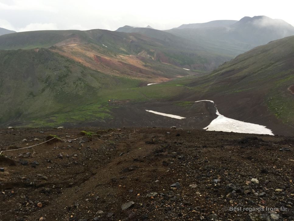 View on the Daisetsuzan Grand Traverse hiking trail covered in clouds and patches of snow, Hokkaido, Japan.