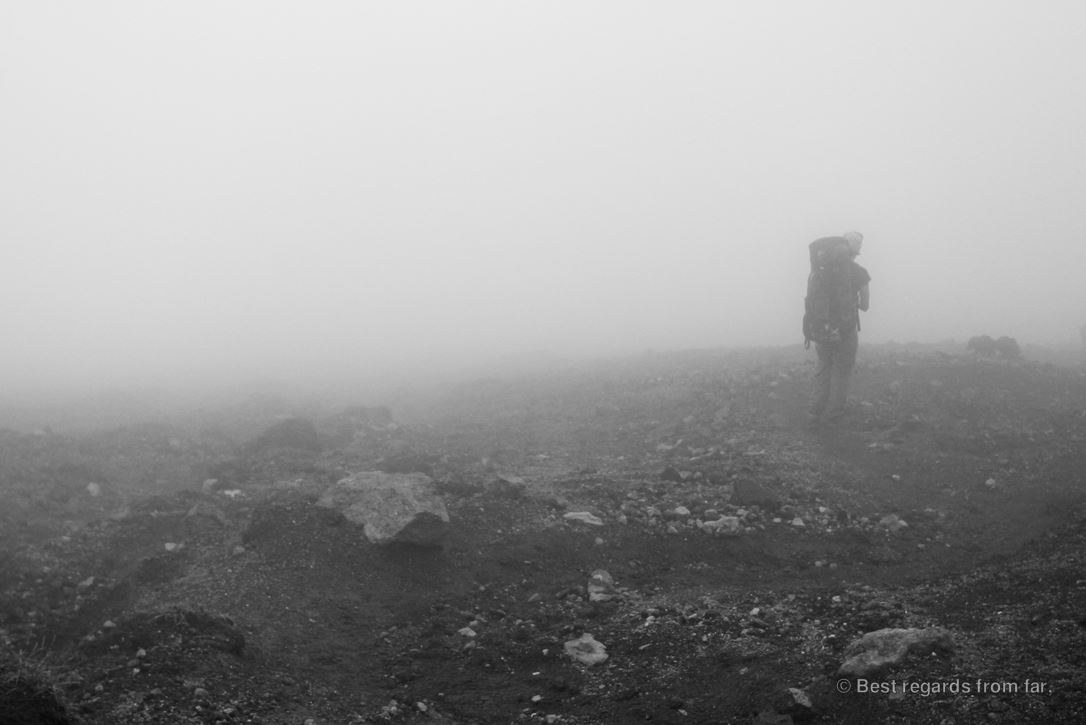 Hiker with a heavy backpack in the clouds on the Daisetsuzan Grand Traverse hike.