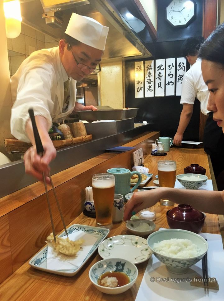 Tempura chef serving the tempura to a patron in a Japanese tempura-ya restaurant in Tokyo.