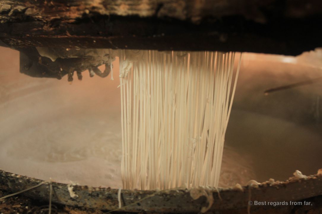 Rice noodles above boiling water.