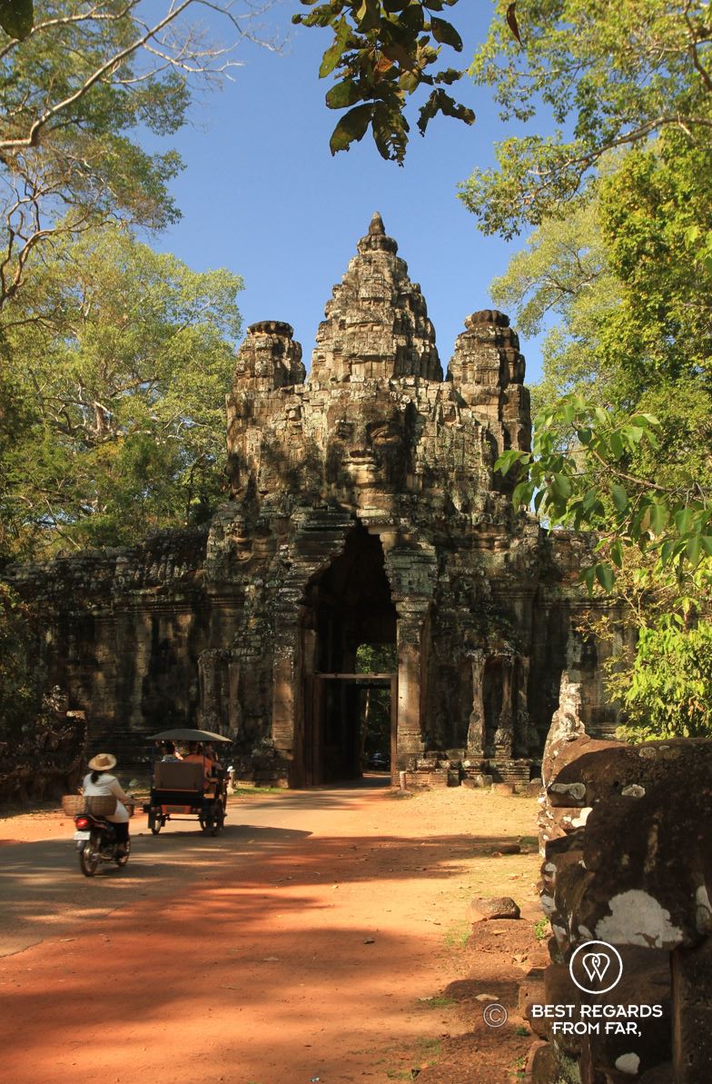 The Victory Gate of Angkor Thom with a tuktuk and woman on a bicyle.