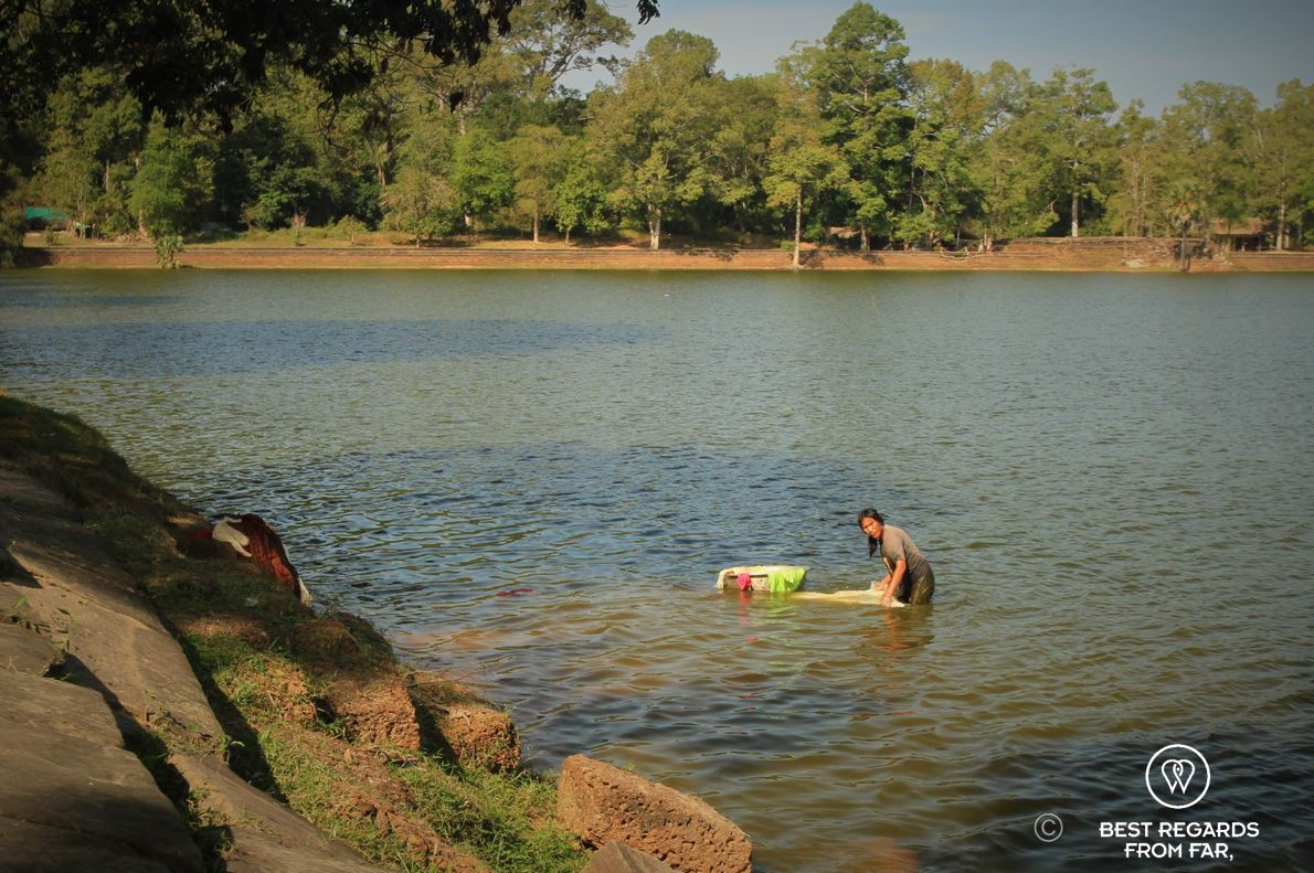 A woman doing laundry in the baray of Angkor, Cambodia.