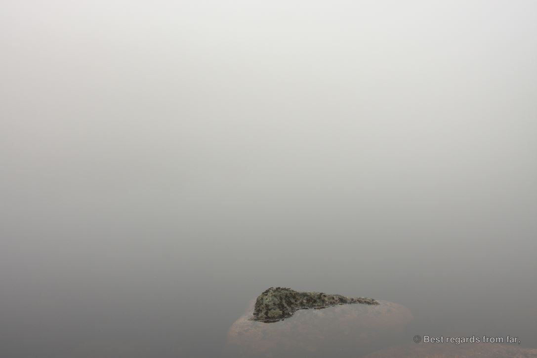 Rock merging into a misty lake along the High Coast trail (Hoga Kusten), Sweden