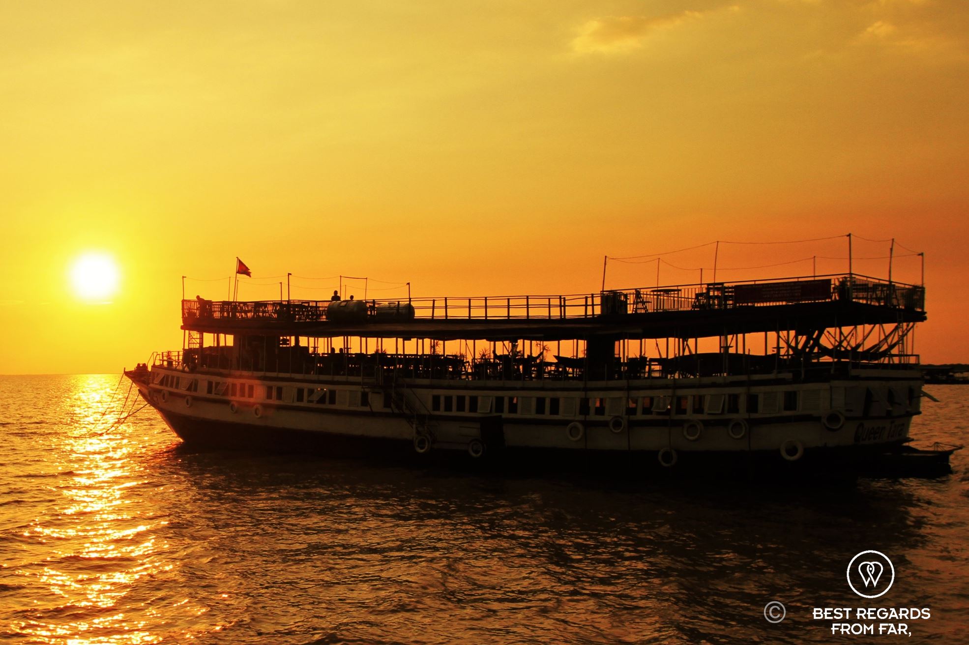 Large boat in sunset light on a lake.