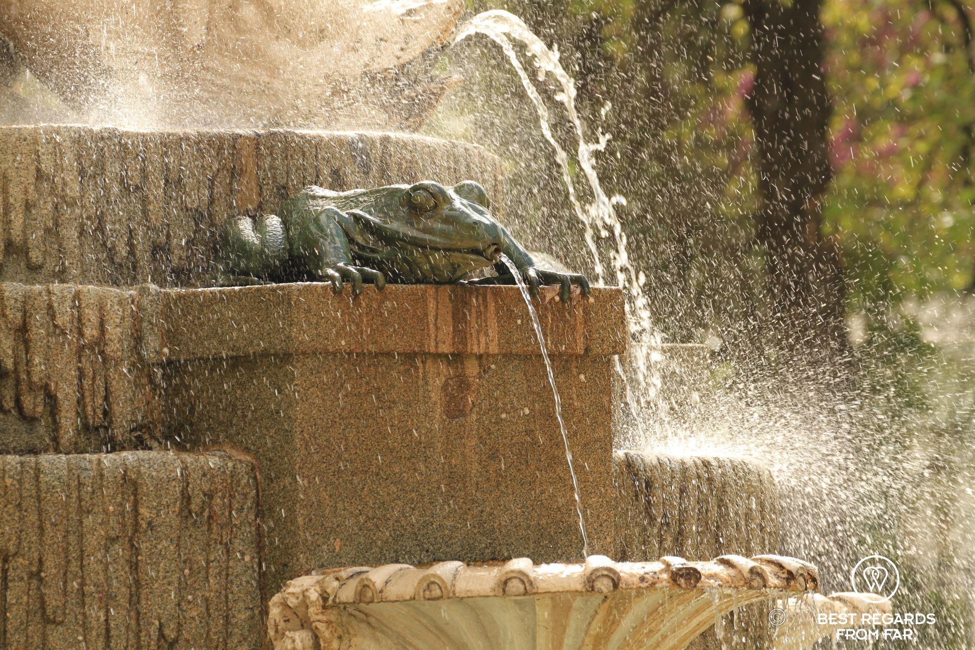 Close up of a bronze tod fountain spewing water at El Buen Retiro Park in Madrid.