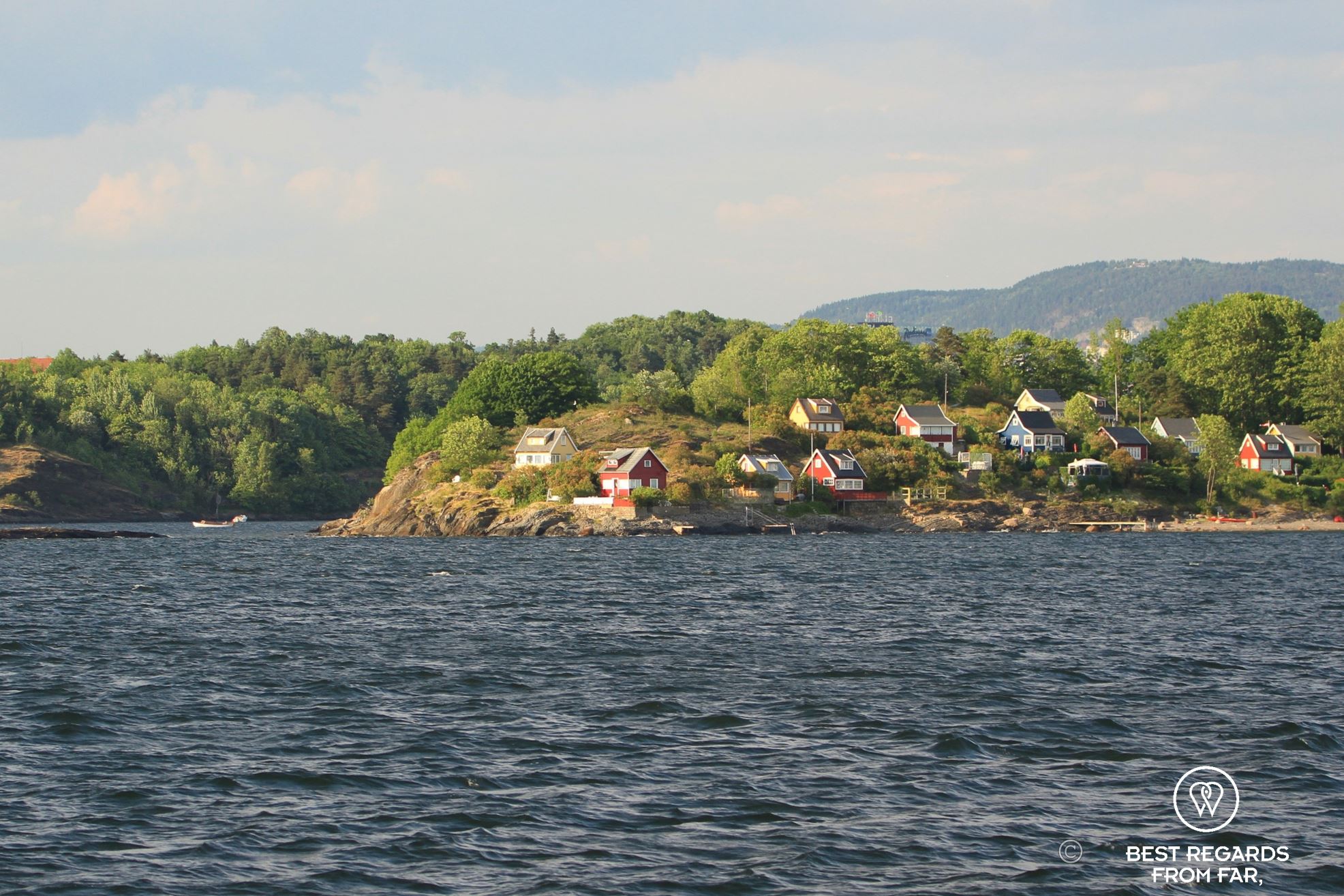 Small island with wooden houses seen from the water. Bleikoya, Oslo, Norway.