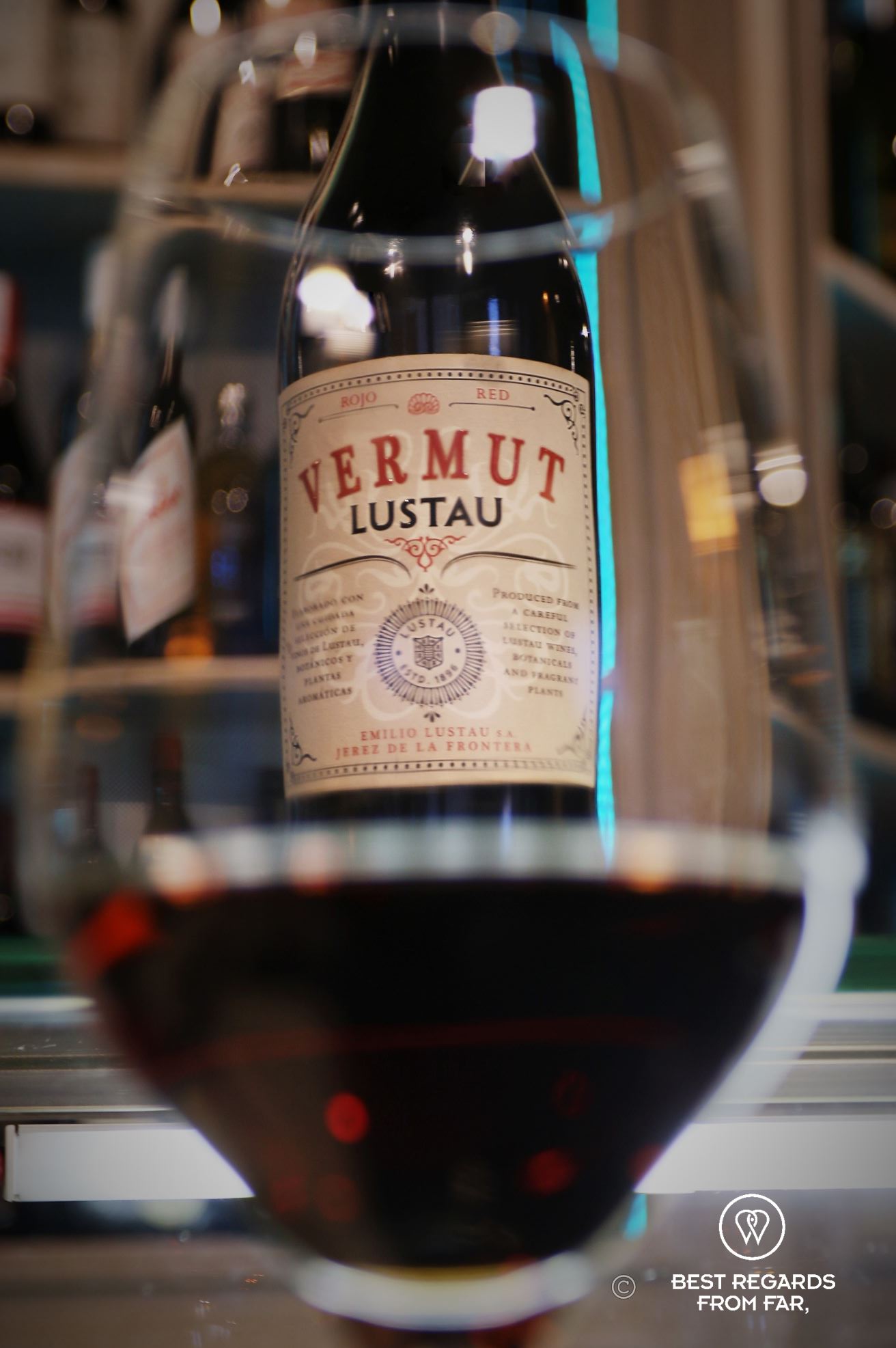 A bottle of Lustau vermouth seen through a vermouth glass.