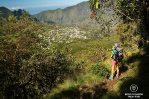 A multiday hiker looking at a view on the city of Cilaos on the exclusive hike through the 3 cirques, Reunion Island.