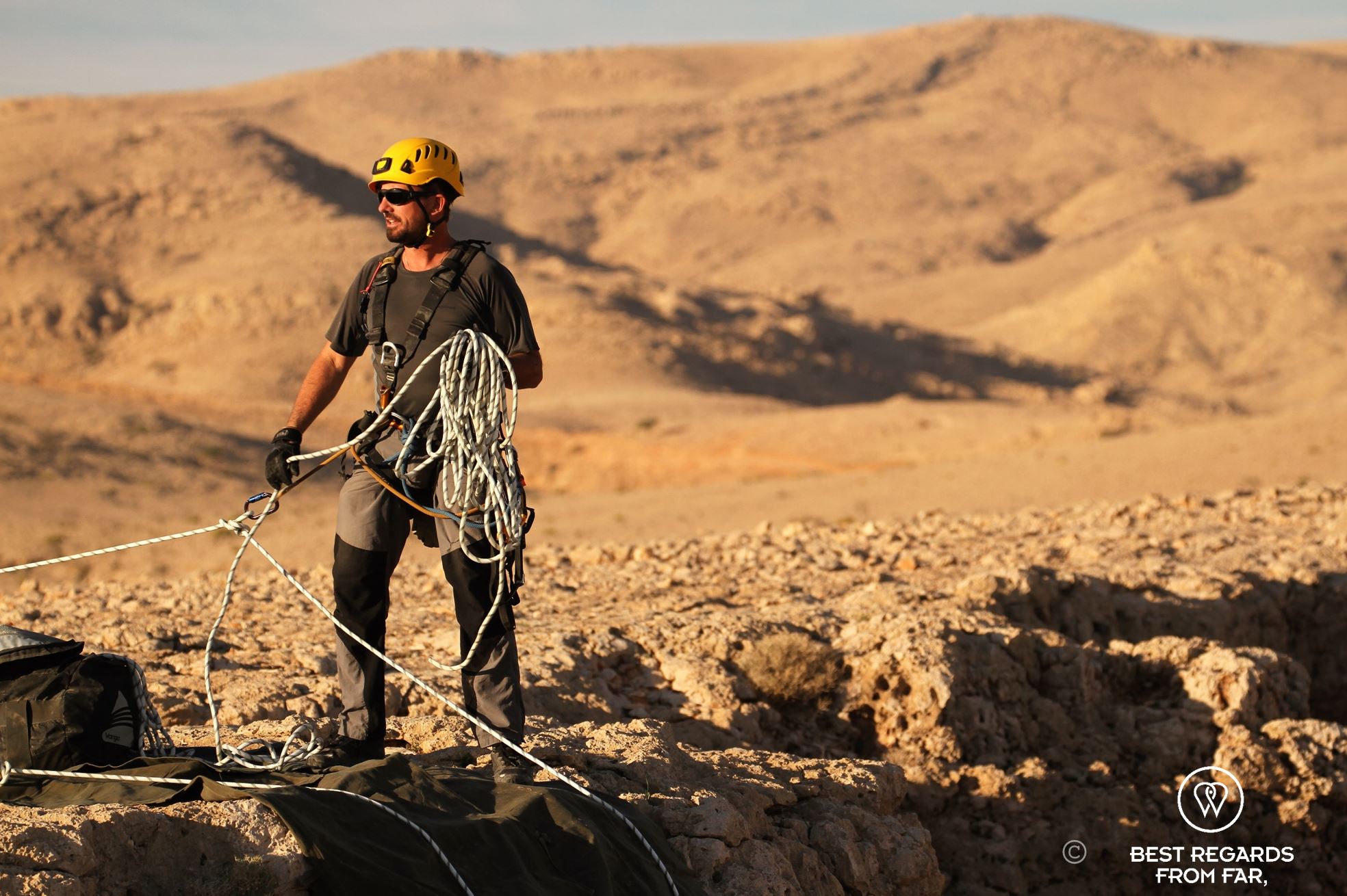 The expert caving guide Justin Hall all geared up and ensuring safety on the Selma Plateau during the Seventh Hole caving expedition in Oman.