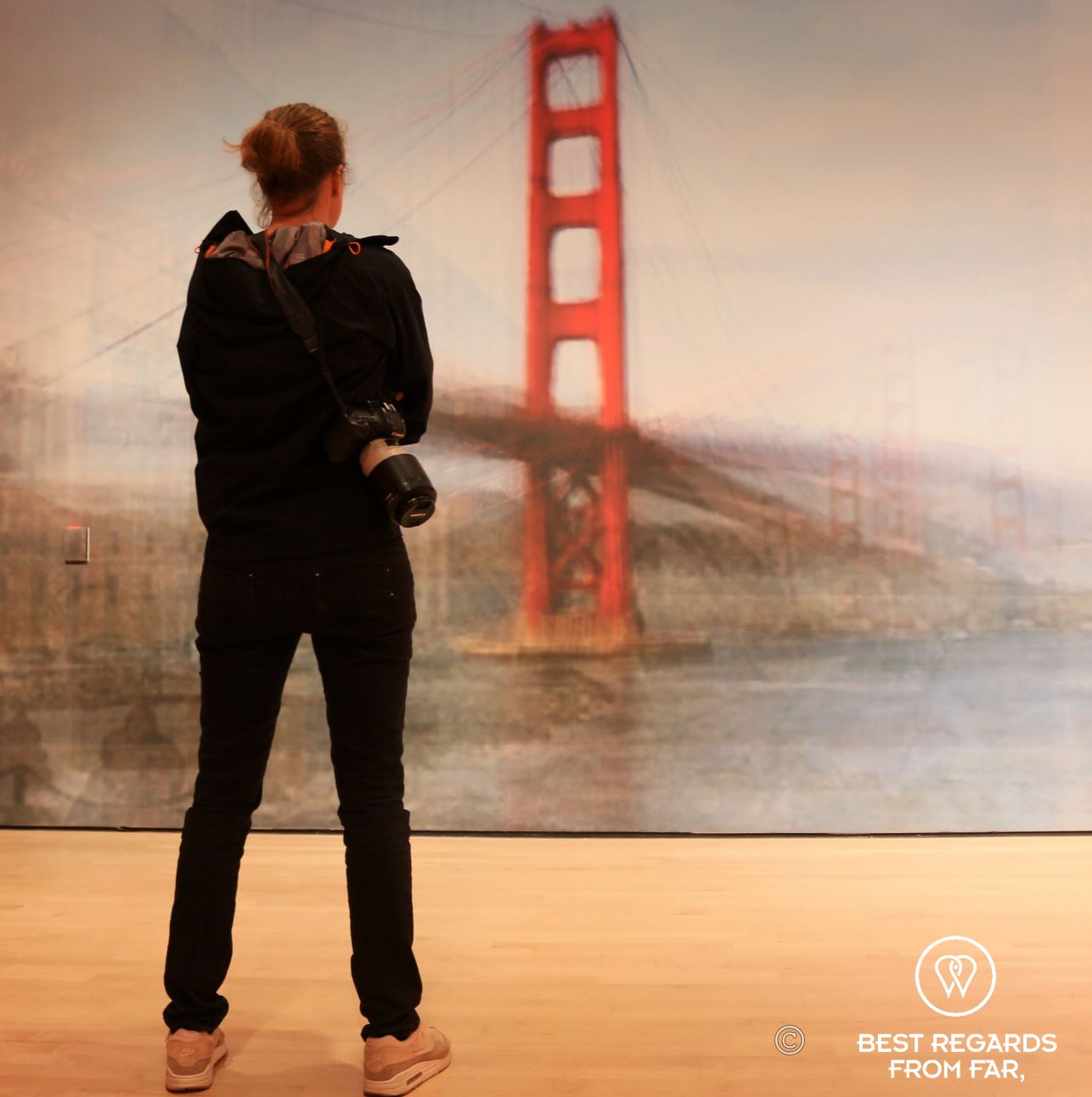 Photographer Marcella van Alphen taking in the art featuring the Golden Gate Bridge.