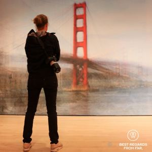 Photographer Marcella van Alphen taking in the art featuring the Golden Gate Bridge.