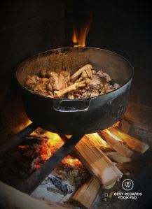 Chicken feet cooking on a woodfire in a cast iron pan, Reunion Island