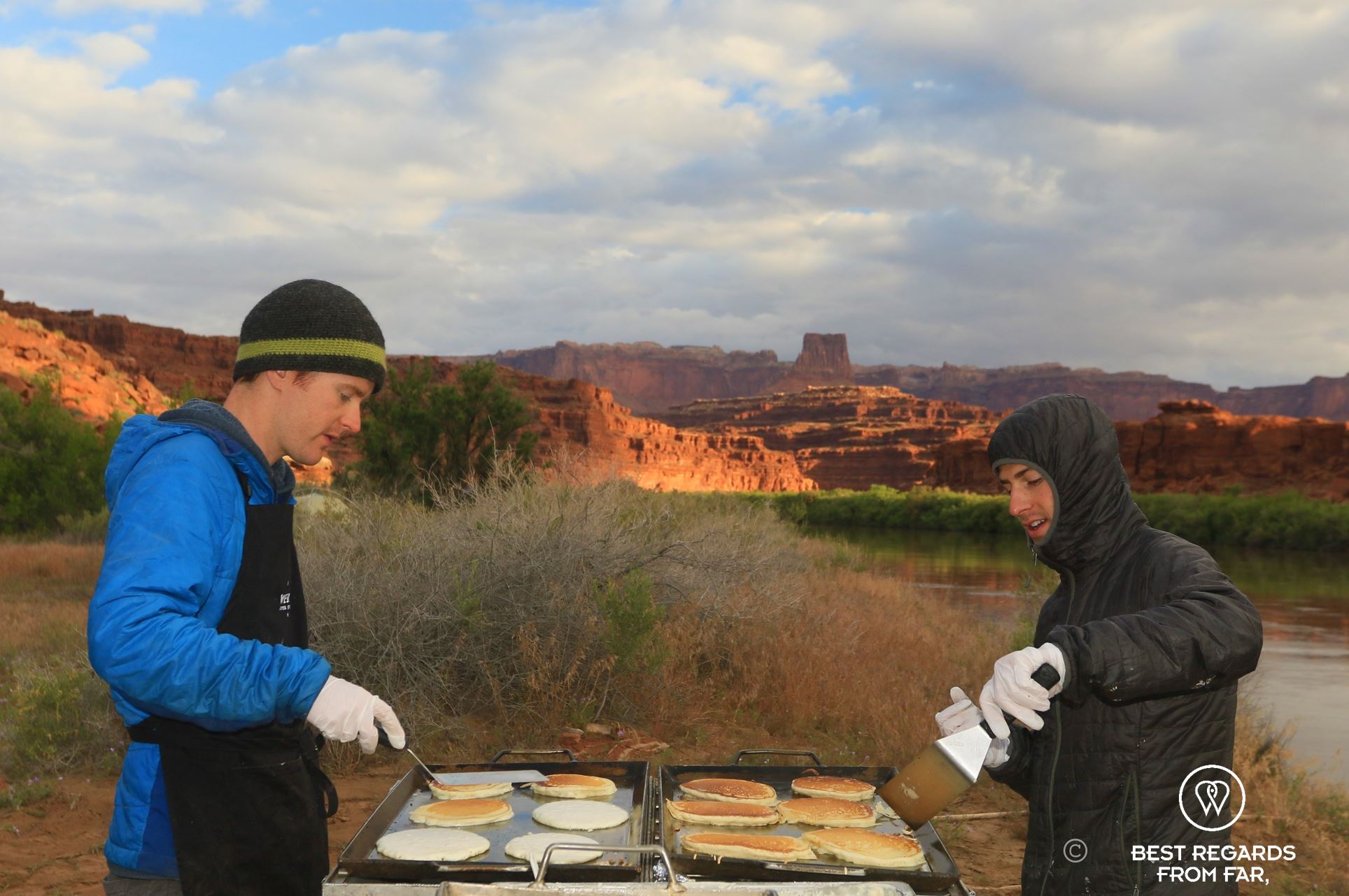 River guides baking pancakes at sunrise on the banks of the Colorado River, during the Cataract Canyon rafting expedition with Western River Expeditions.