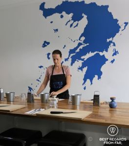 Woman with black apron preparing a wooden table.