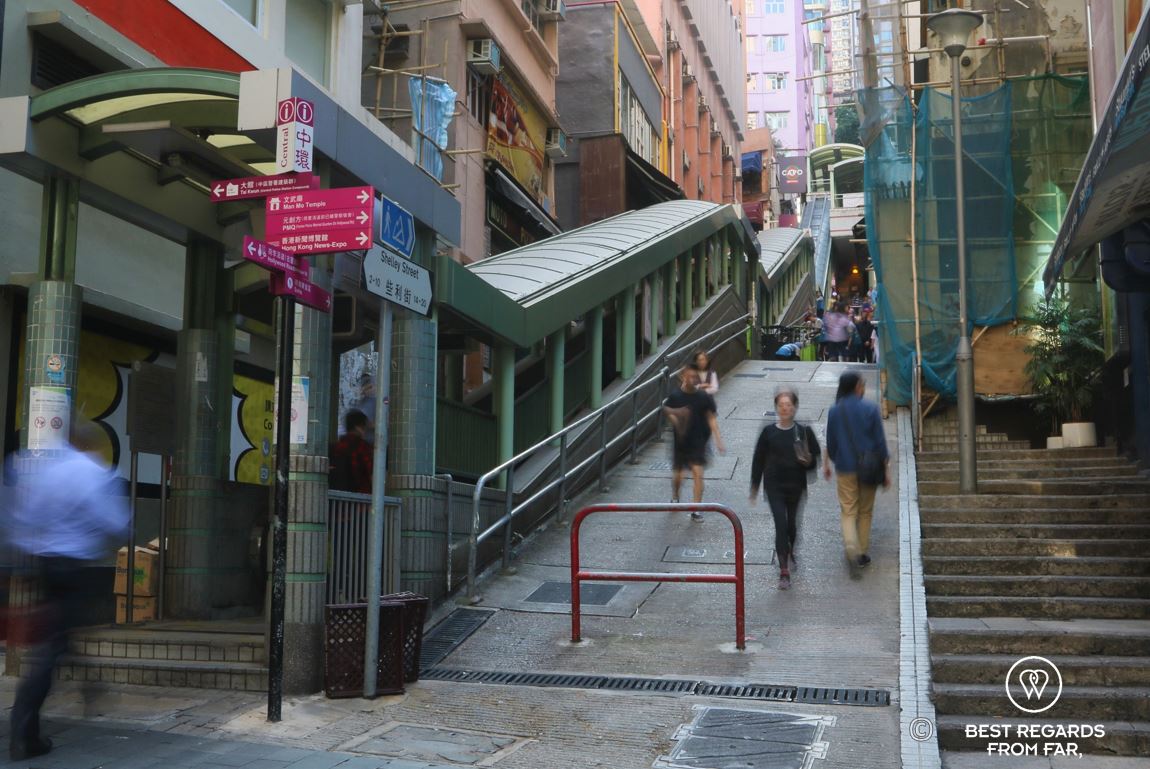 Hong Kongers walking fast by the mid-levels escalators on Hong Kong Island