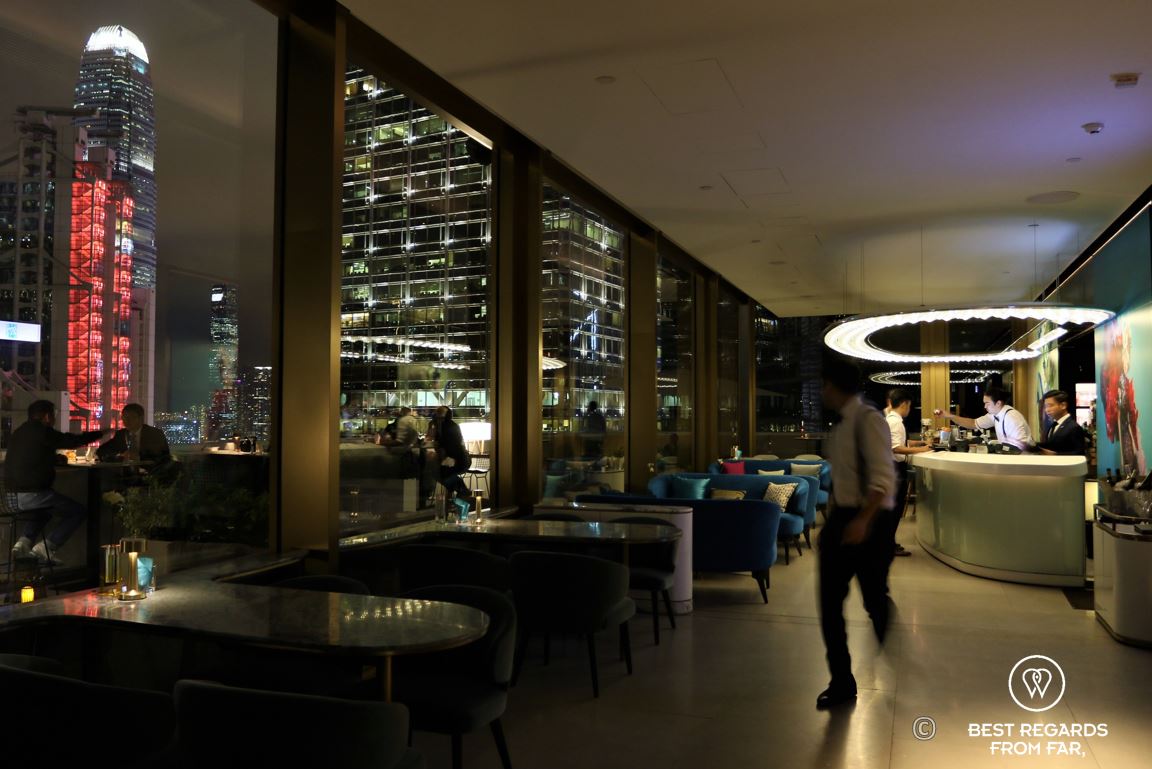 Waiter and patrons at the Popinjays stylish rooftop cocktail bar at night with lit towers, the luxurious Murray Hotel, Hong Kong Island