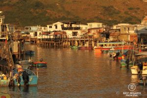 Water with colourful boats and on each side houses on stilts, Tai O fishing village, Lantau Island, Hong Kong.
