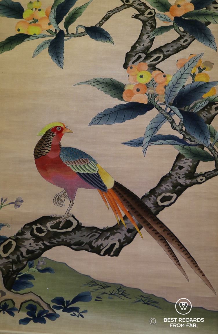 Exotic and colorful bird on an oriole silk tapestry on display at the University Museum, Hong Kong Island