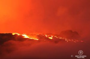 The Furnace Peak volcano in eruption in with the bright red lava in fusion and the red sky