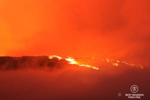 The Furnace Peak volcano in eruption in with the bright red lava in fusion and the red sky