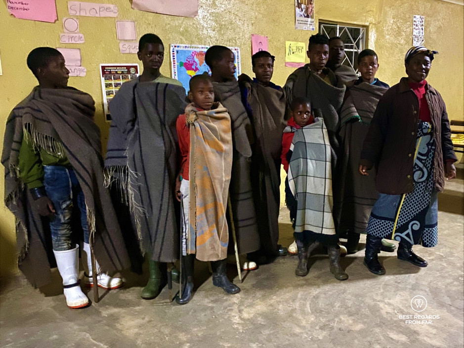 The shepherd's school in Eastern Lesotho with young men in traditional clothes and their proud teacher