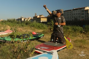 Tommaso Pucci at Toscana SUP explaining stand up paddling on the bank of the Arno River, Florence, Italy.
