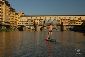 Stand up paddling the Arno River by the Ponte Vecchio in Florence, Italy.