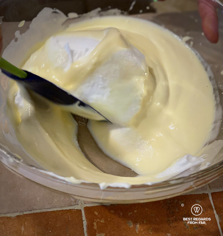 Recipe of tiramisu: slowly adding the egg whites to the cream of mascarpone, egg yolks and sugar.