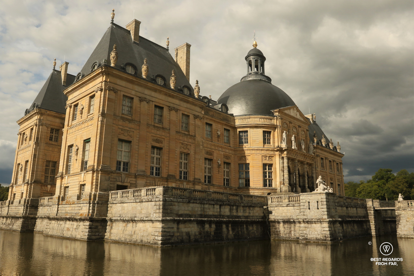 Castle of Vaux-le-Vicomte and its moat in the summer evening sun.