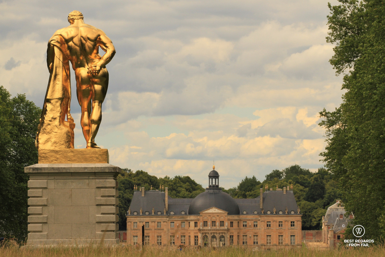 The castle of Vaux le Vicomte seen from the French garden with the golden sculpture of Hercule.