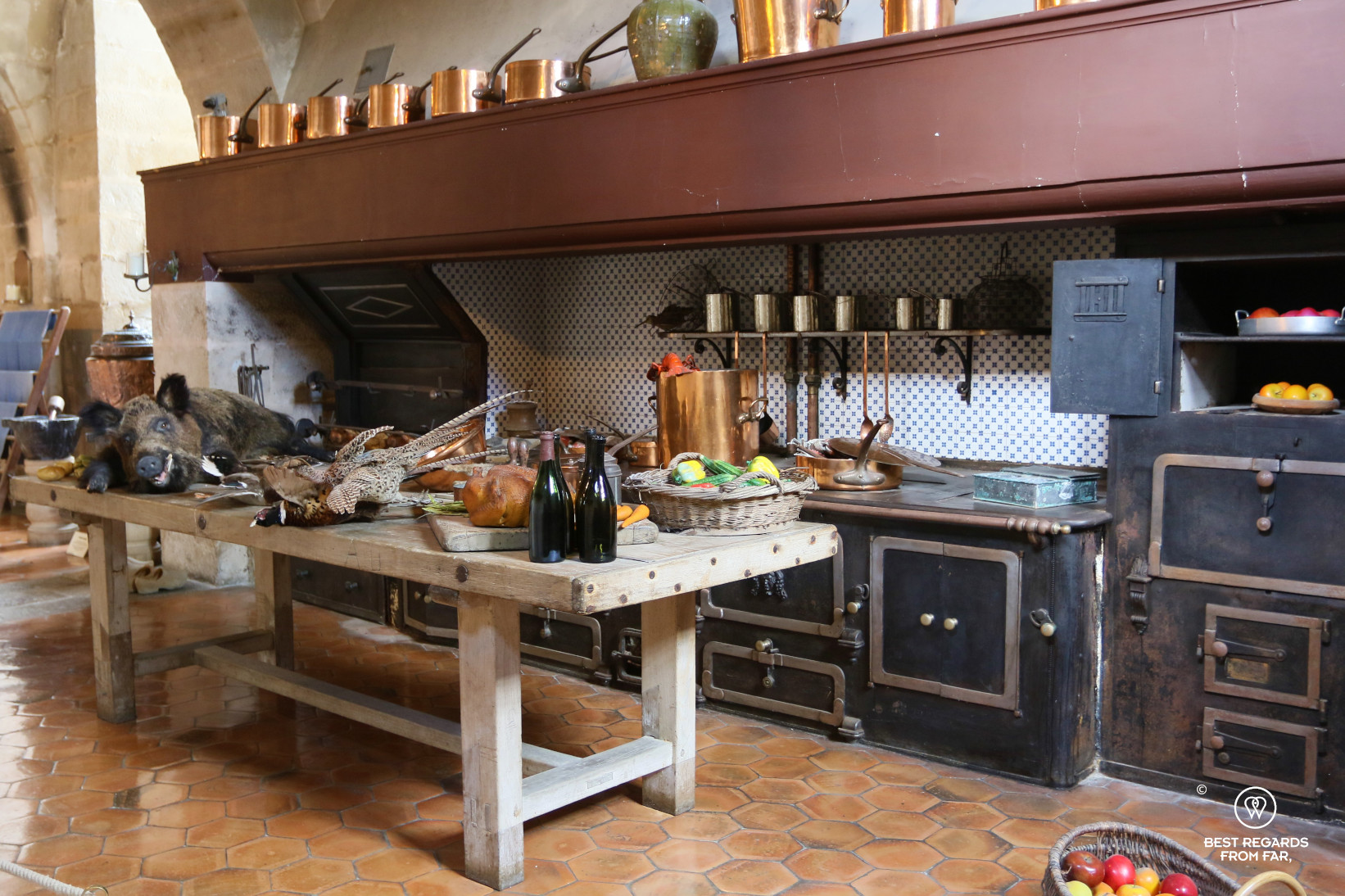 The kitchen of the castle of Vaux le Vicomte, France with its copper pots, abundant food and ancient stove.