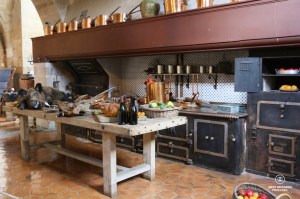 The kitchen of the castle of Vaux le Vicomte, France with its copper pots, abundant food and ancient stove.