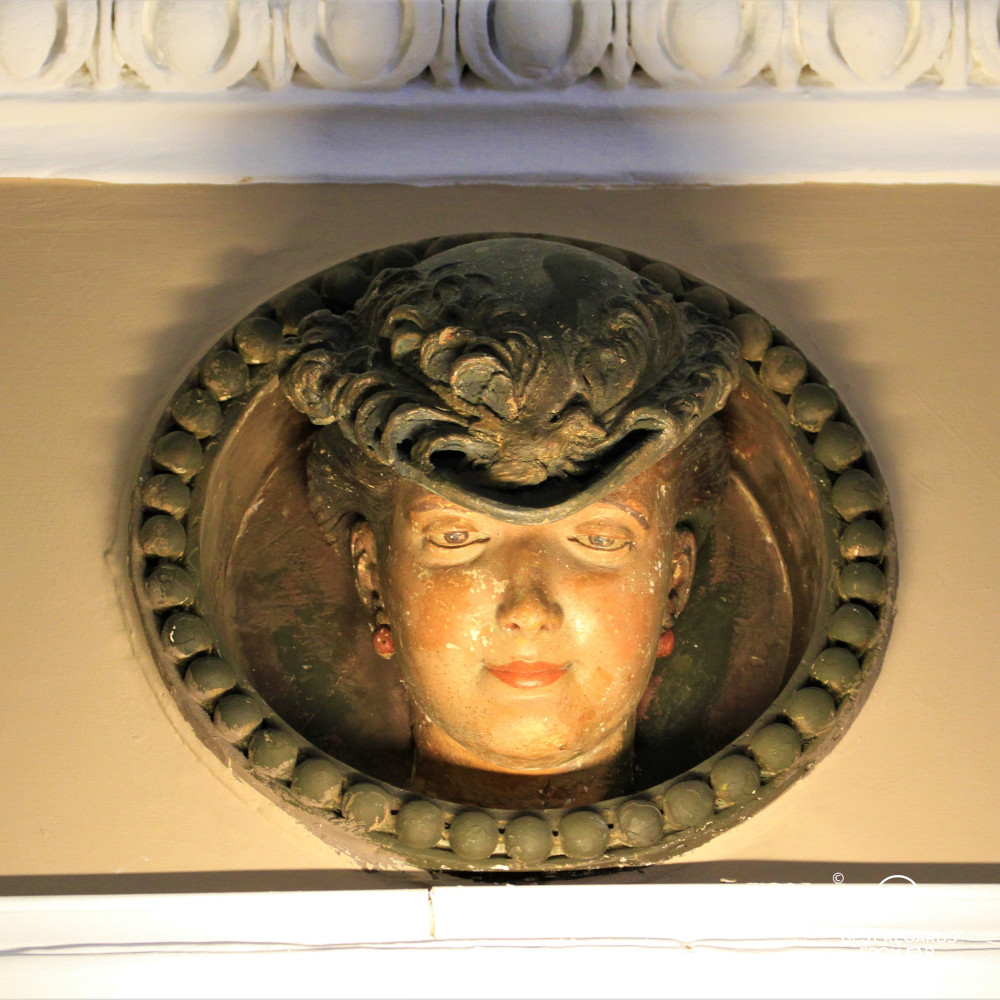 Detail of the lobby of the Bernini Palace, Florence, showing a wooden sculpture of a woman with a hat