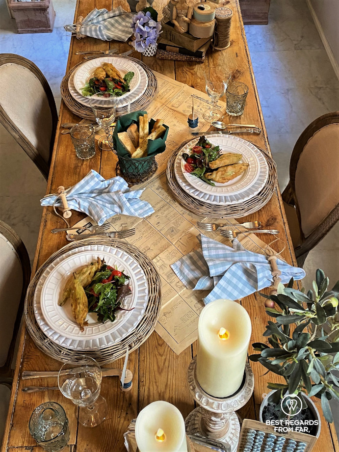 Wooden table with food for three people, candles and napkins