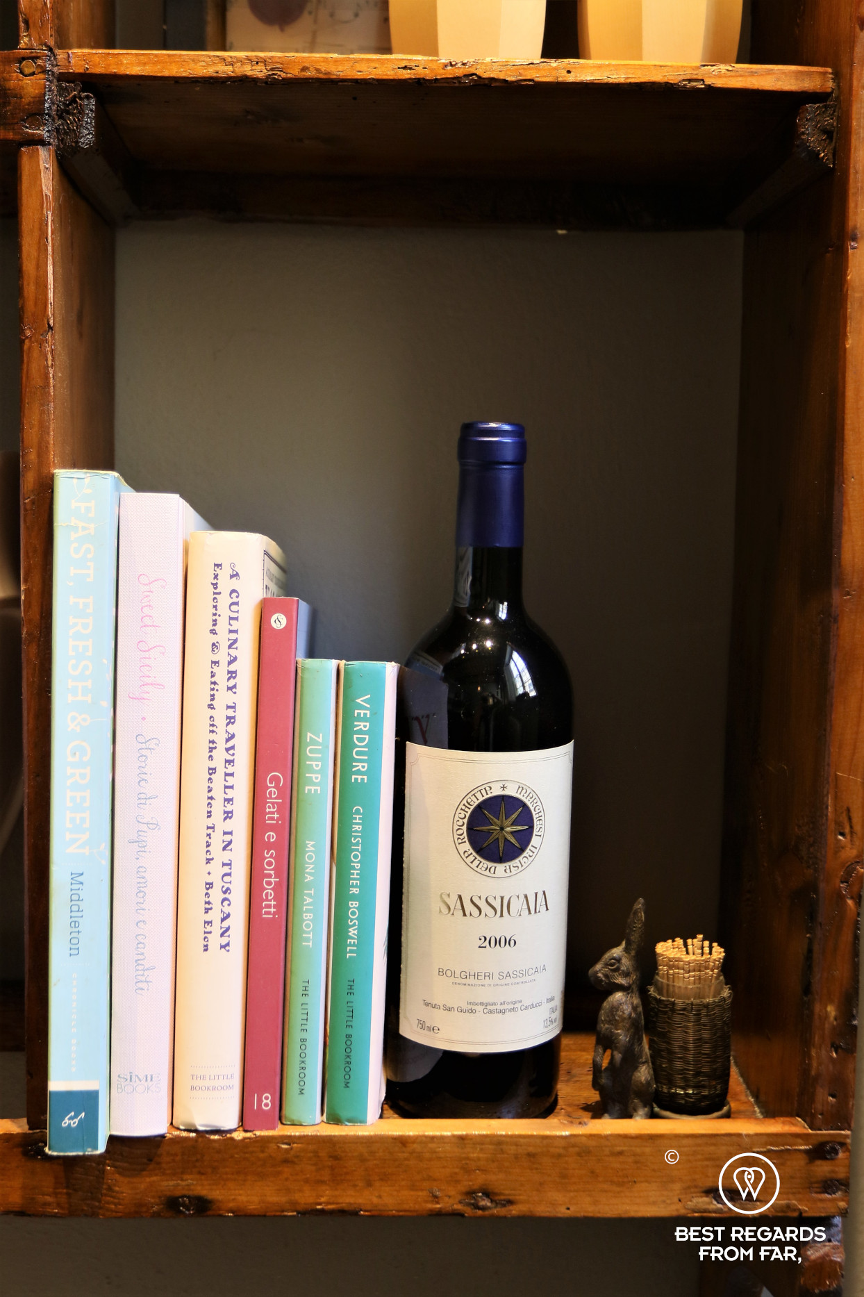 Cooking books and a bottle of wine and some toothpicks