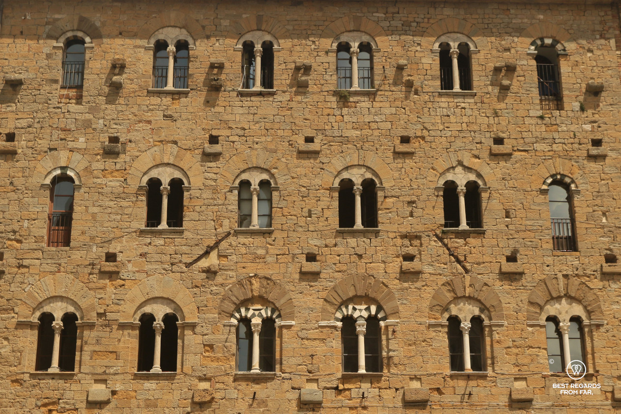 Palace wall with many arched windows in Volterra, Tuscany, Italy