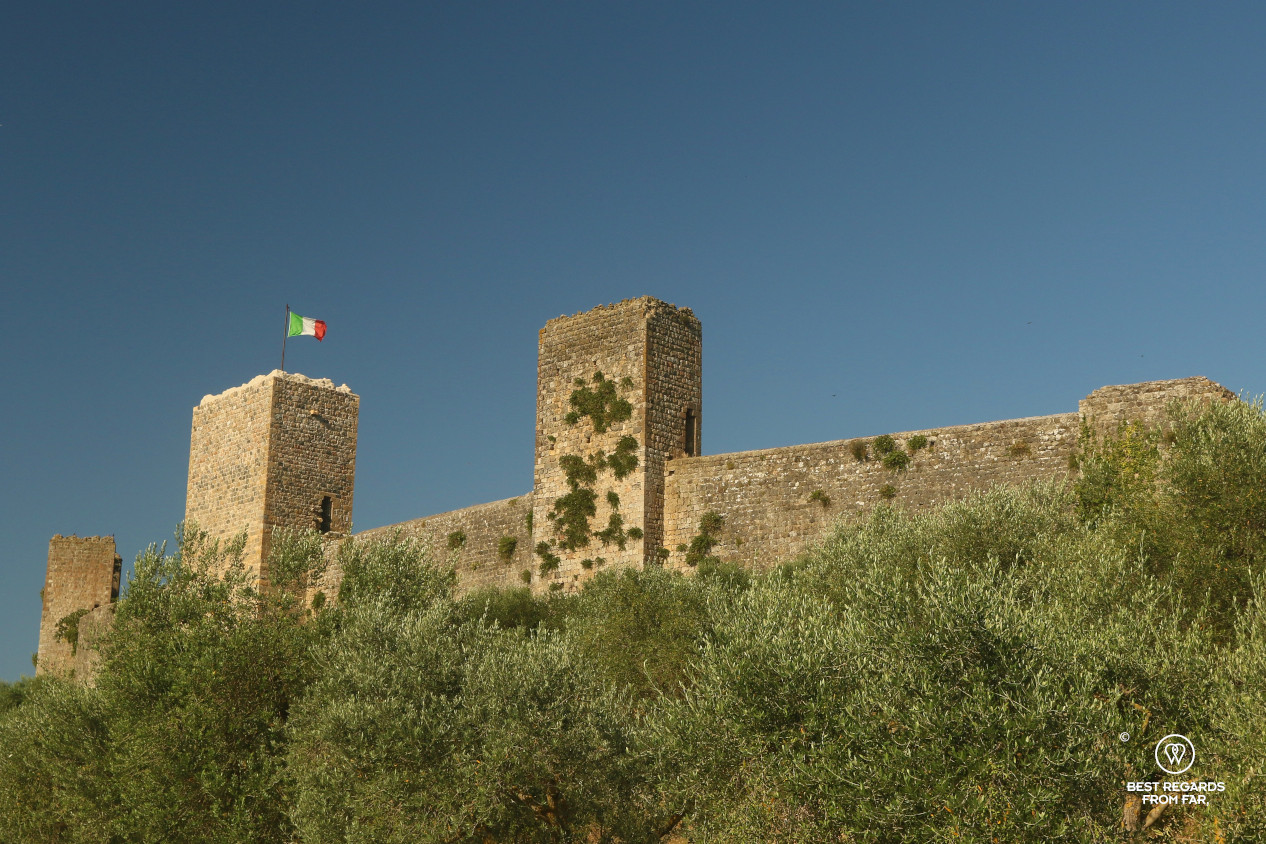 The fortified medieval wall of Monteriggioni with the Italian flag