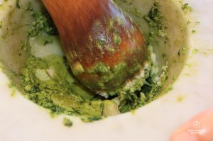 Crushing the Italian cheese with the ingredients in a Carrara marble mortar to make pesto