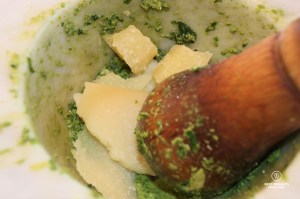 Crushing the Italian cheese with the ingredients in a Carrara marble mortar to make pesto