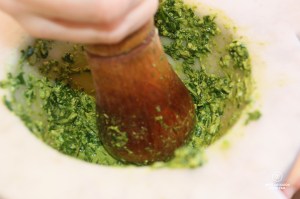 Crushing the ingredients in a Carrara marble mortar to make pesto, Cinque Terre, Italy