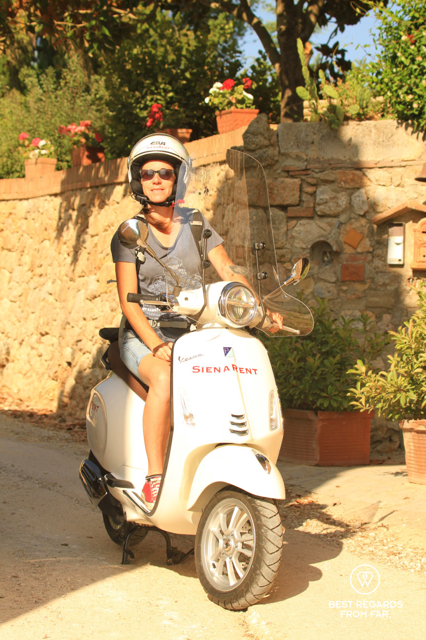 A woman in Tuscany on a white Vespa scooter, Italy