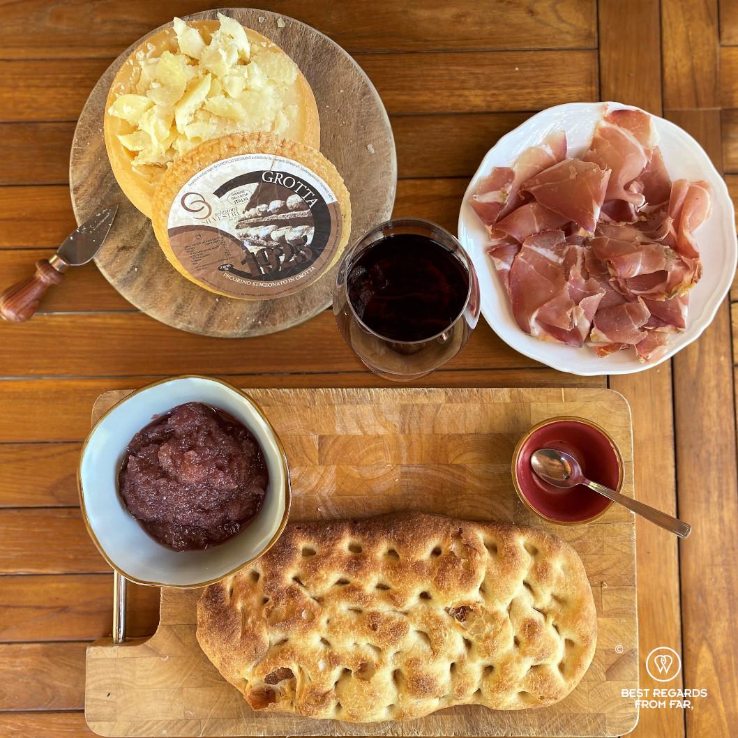 Grotta cheese, raw ham and focaccia on a wooden table