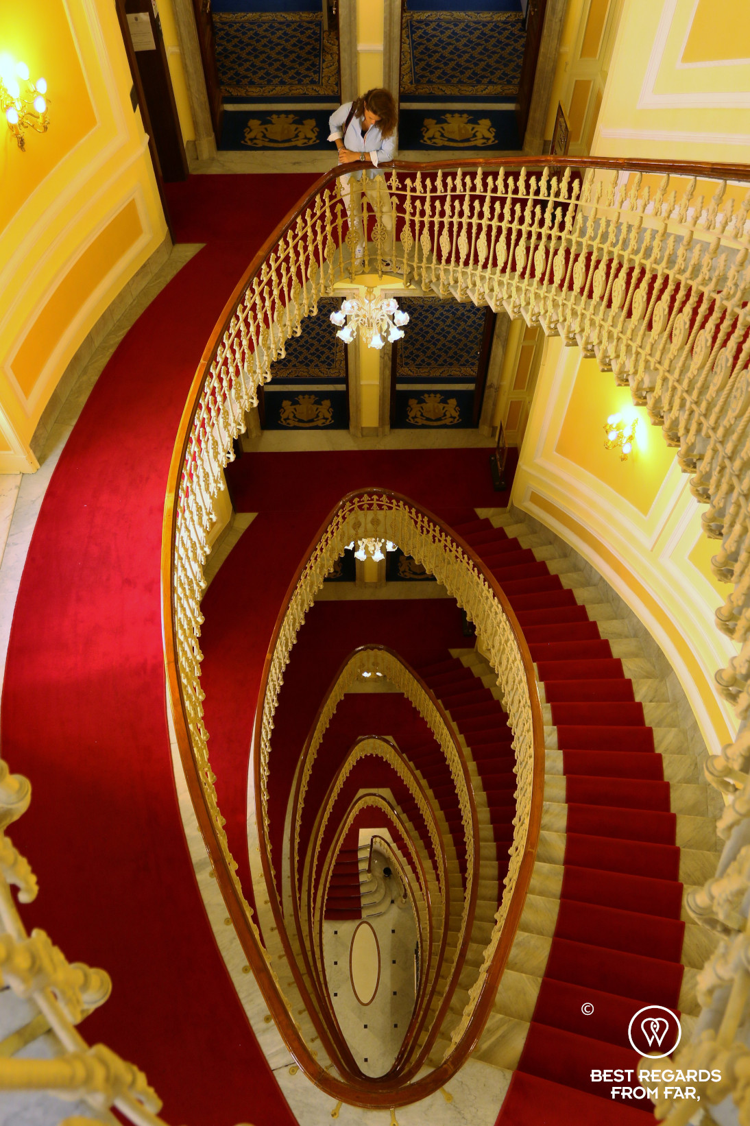 The red-carpetted spiral staircase of the the Hotel Bristol Palace in Genoa, Liguria, Italy