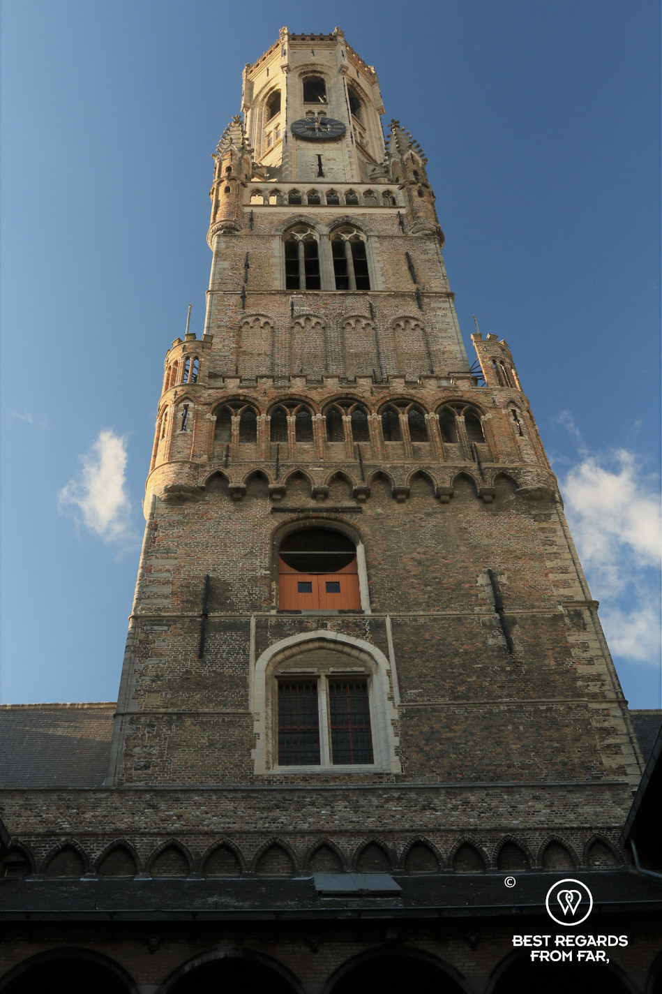 The Belfry of Bruges, Belgium, against a blue sky.