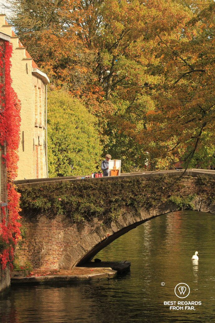 A painter painting Bruges' skyline on a bridge