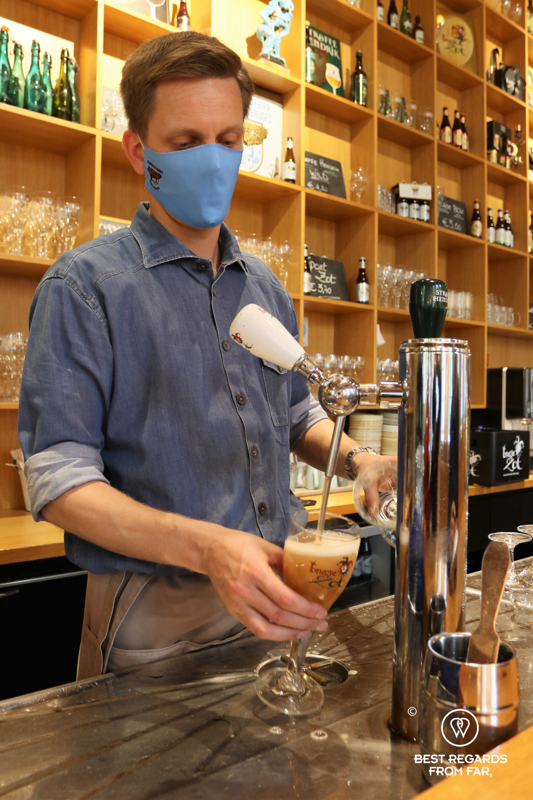 Bartender serving a beer on the tap at De Halve Maan brewery, Bruges, Belgium.