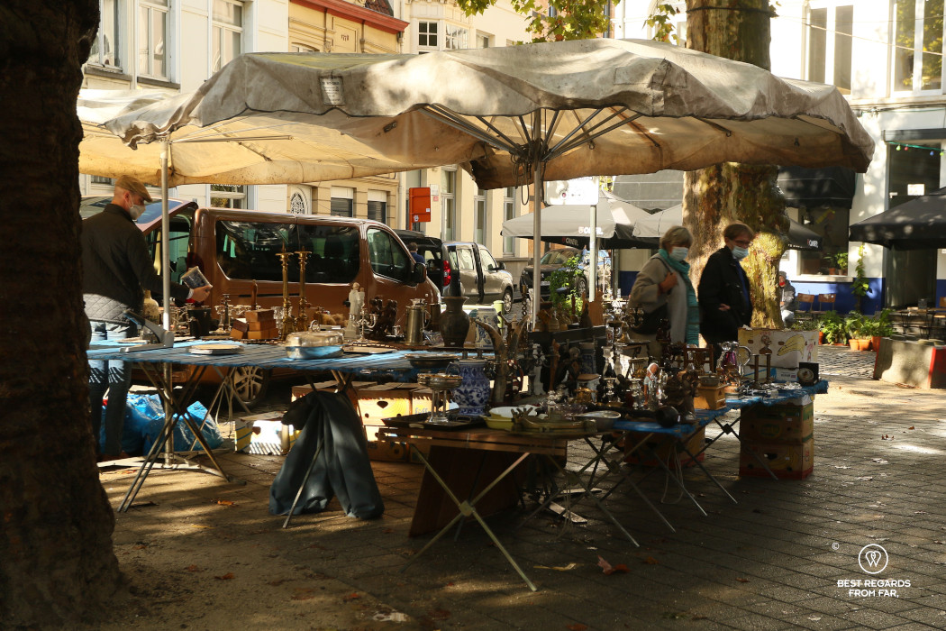 Two people looking at antique ornaments on a flea market in Belgium